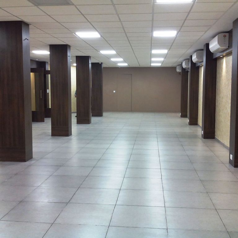 Spacious corridor or hall with tiled floor and wooden columns
