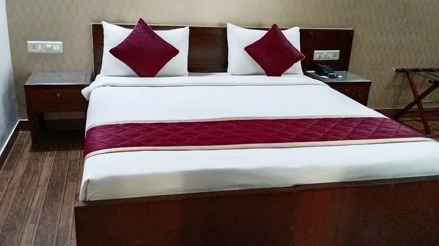 A clean and inviting bed with crisp white and red linen promises a comfortable night's sleep at Lords Midtown Suites.
