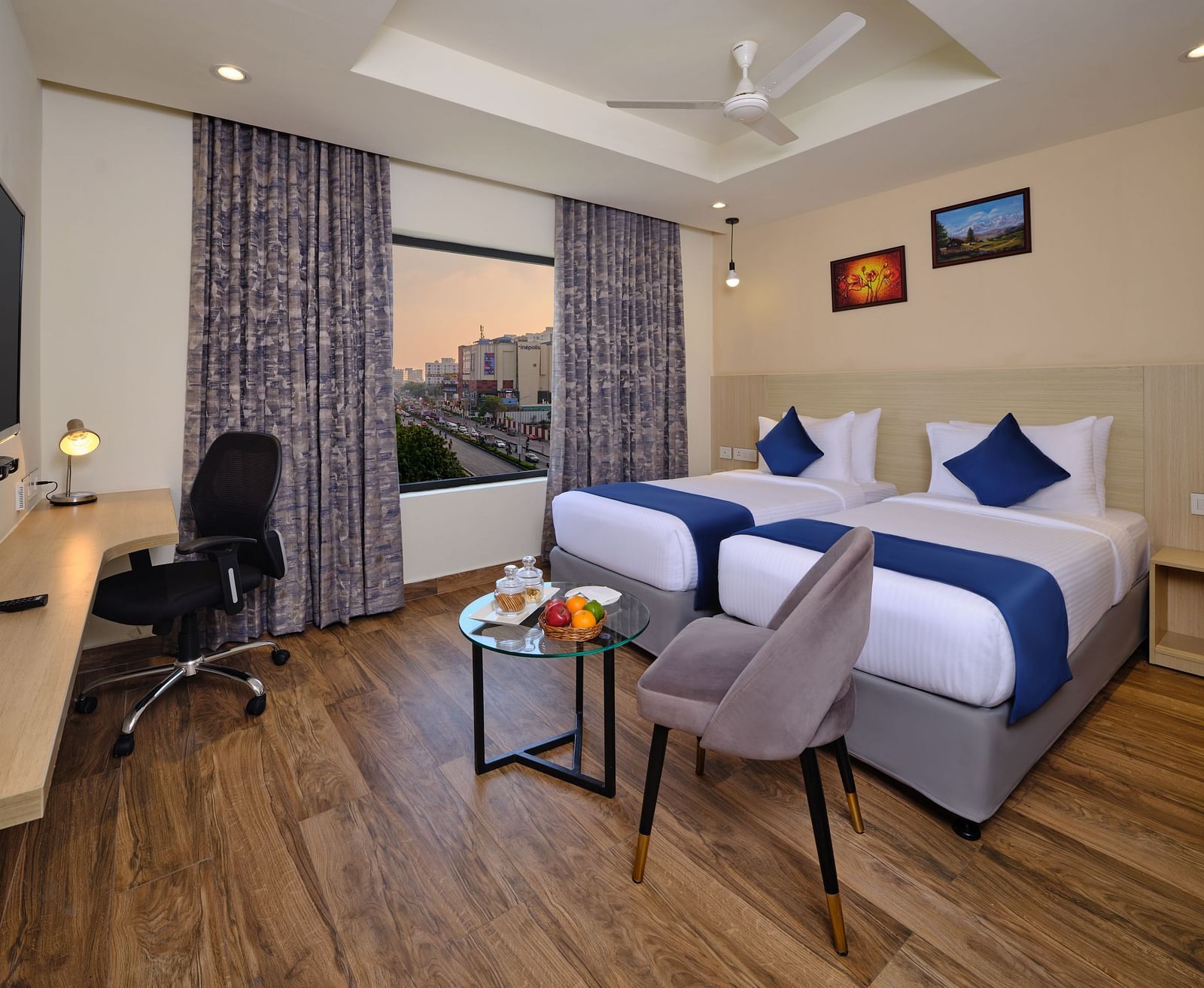 A room at Essentia Premier Hotel, Chennai with twin beds, a television and work desk and chair
