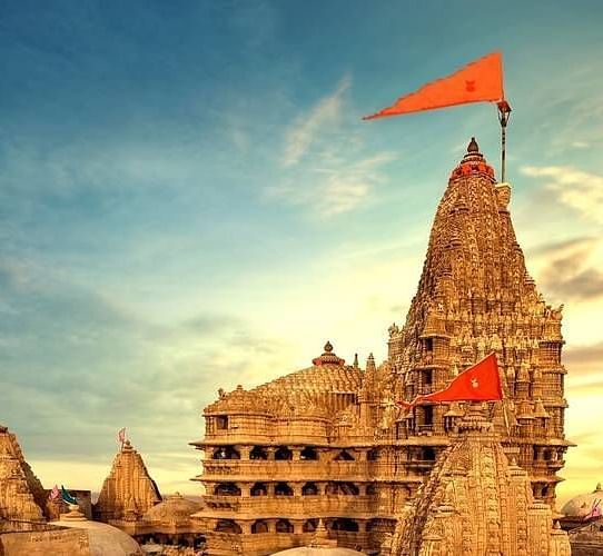 image of a temple with orange coloured flags hoisted with a mesmerising sunset in the background