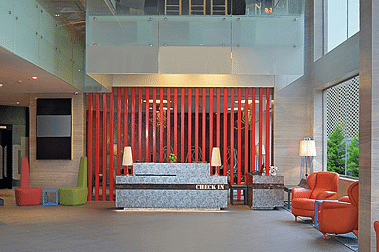 Modern hotel lobby with contemporary decor and a vibrant red accent wall at GRT Hotels.