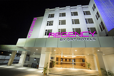 Night view of a GRT hotel exterior with illuminated signage and bright lighting.