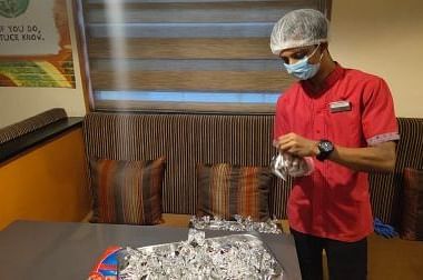 GRT Hotel staff wearing a mask while packing food.