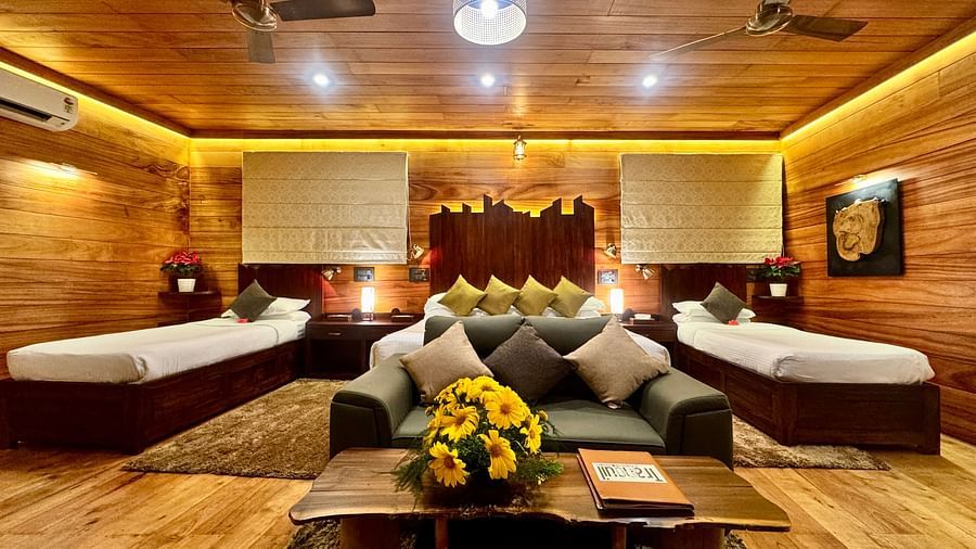 Wooden interior of a room with twin beds, a seating area, and warm lighting - BluSalzz Collection - Tranquil Resort, Wayanad