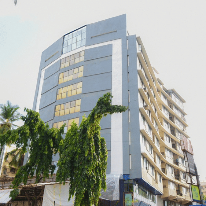 The facade of King's International Juhu with trees by it.