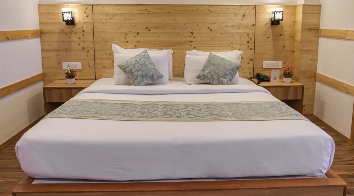 Standard Room at Avianna Gangtok Prime Hotel & Spa featuring a plush bed under warm lighting and two nightstands on both sides with a lamp above each