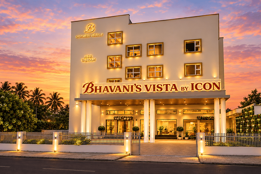 Exterior view of illuminated hotel facade at dusk at Bhavani's Vista By Icon, Hosur.   