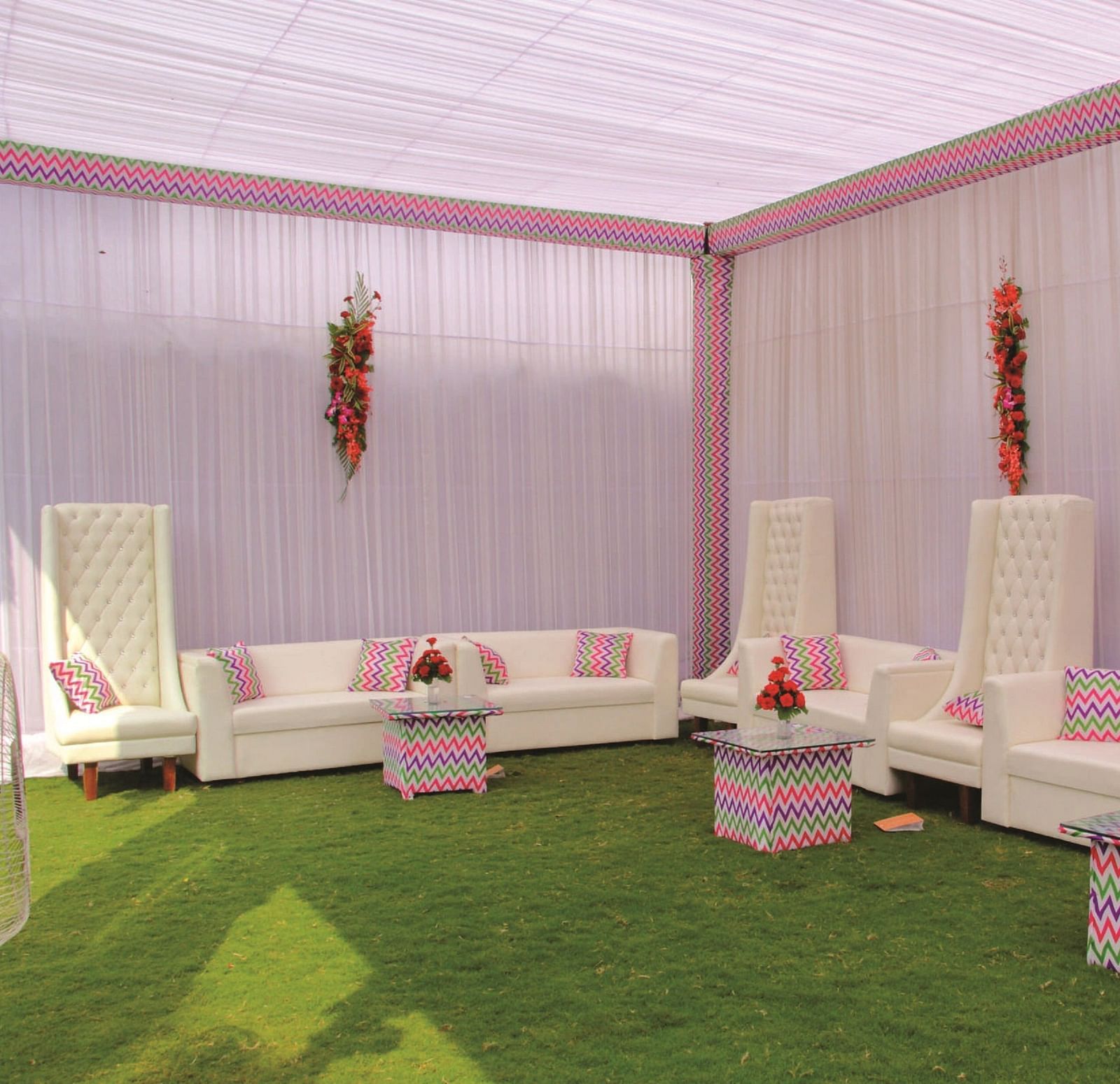Side-angle view of a seating area with white sofas and pink canopy for an event | Gemini Continental