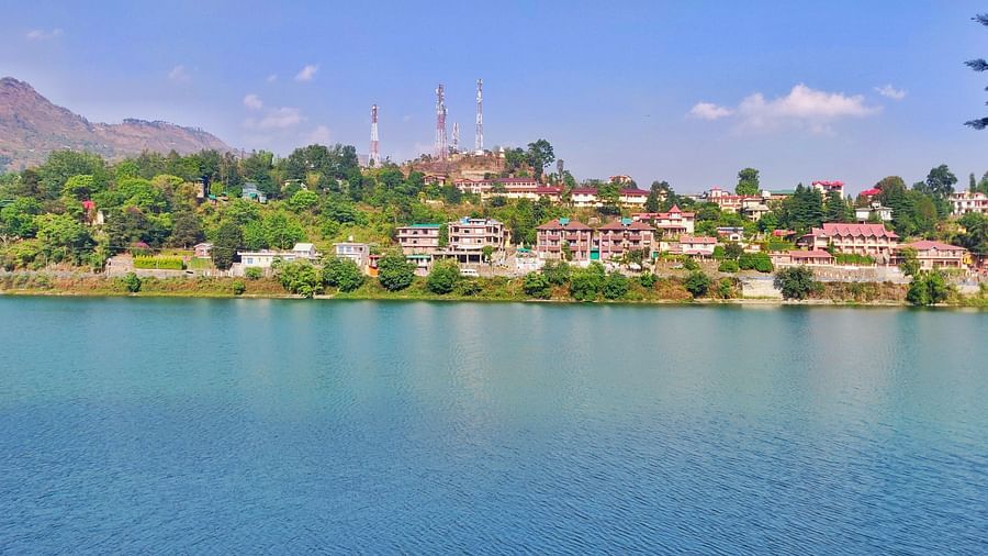 A wide shot of a tranquil lake surrounded by stunning mountains, reflecting the scenic landscape in the water.