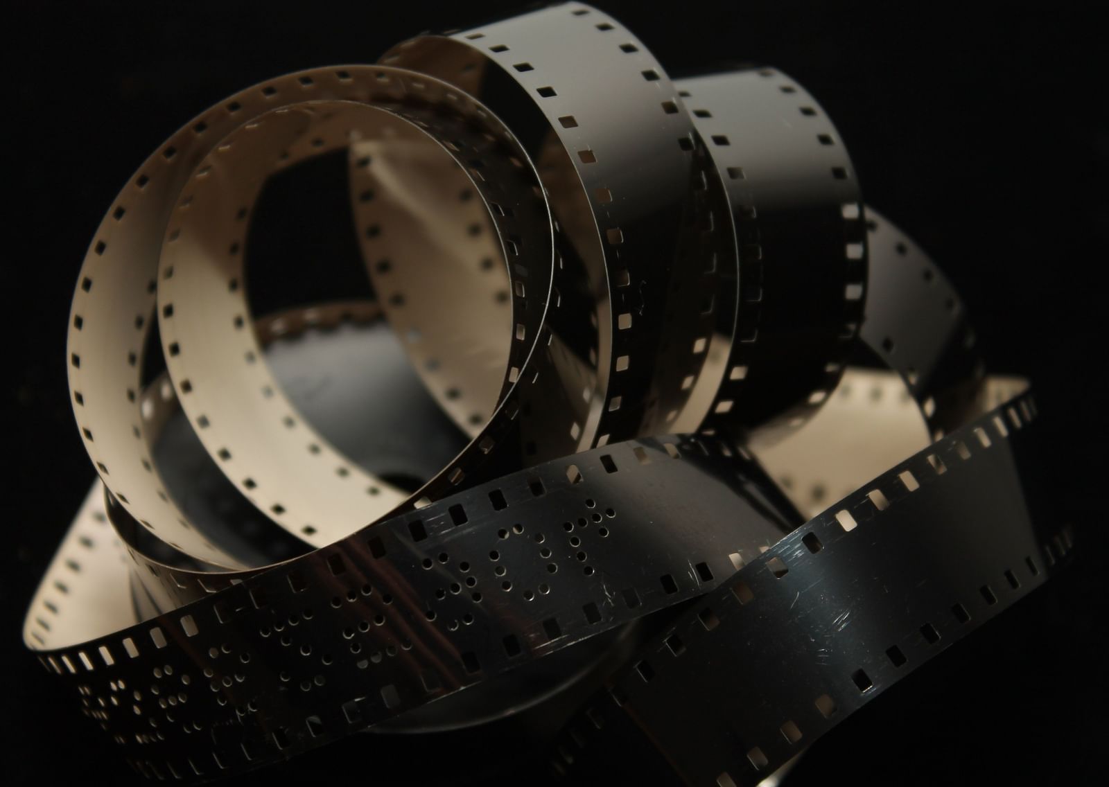 A close up of a roll of negatives to signify a movie with the background blacked out - Pune Film Festival.