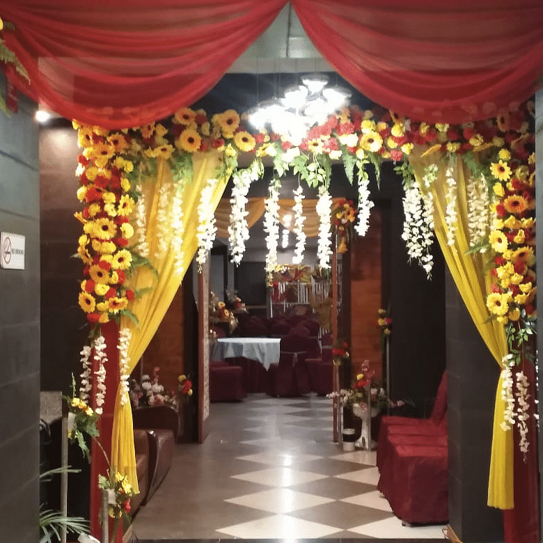 Elegant entrance décor with red drapes, yellow floral arrangements, and warm lighting at Central Courtyard Boutique Hotel.