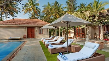 The pathway leading to our cottages by the pool seen during a sunny day - Shreyas Retreat