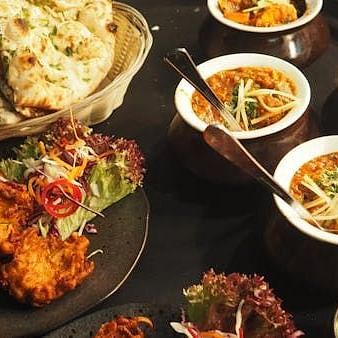 Image of an assortment of Indian dishes neately placed on a table