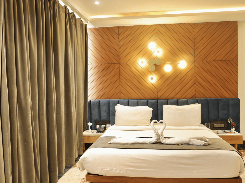 Skyline by Miraya, Venus Family Room, King bed dressed with swan towel art