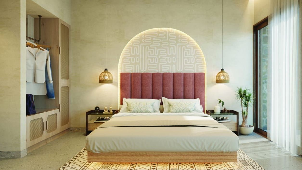 A well-lit, contemporary bedroom has a large bed, a curved arch, and an open wardrobe - Avanya Resorts Private Limited, Chennai