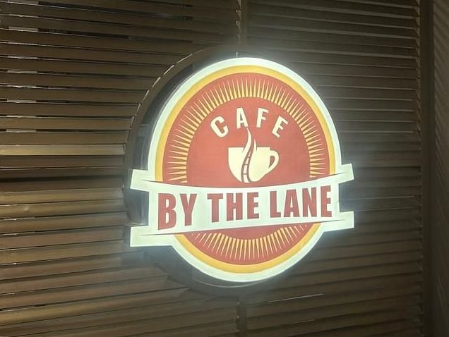 A close-up of a wooden door with the OnTime Hotel logo at The OnTime Hotel, Bangalore.