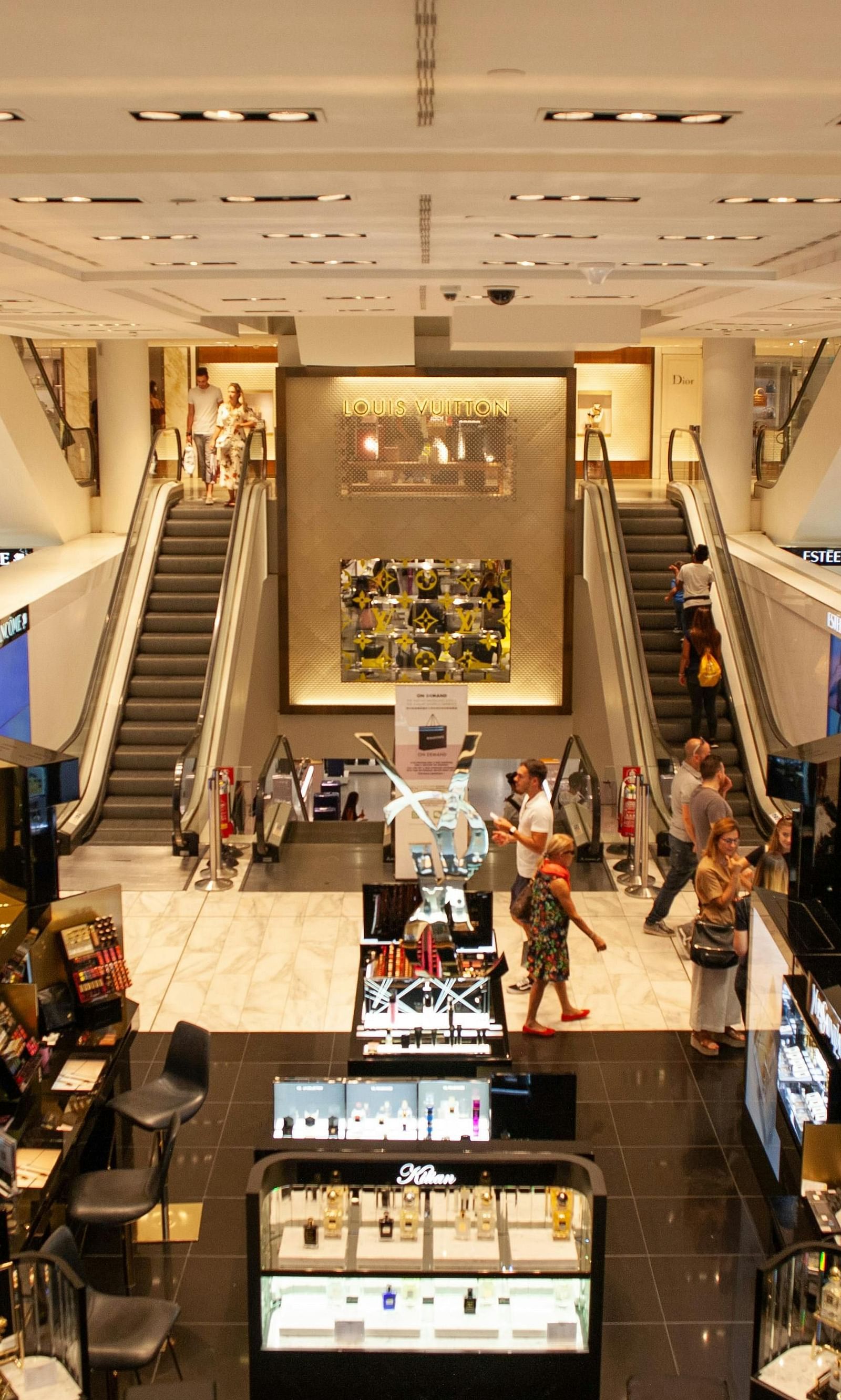 The mall area features numerous stalls along the sides and escalators situated nearby