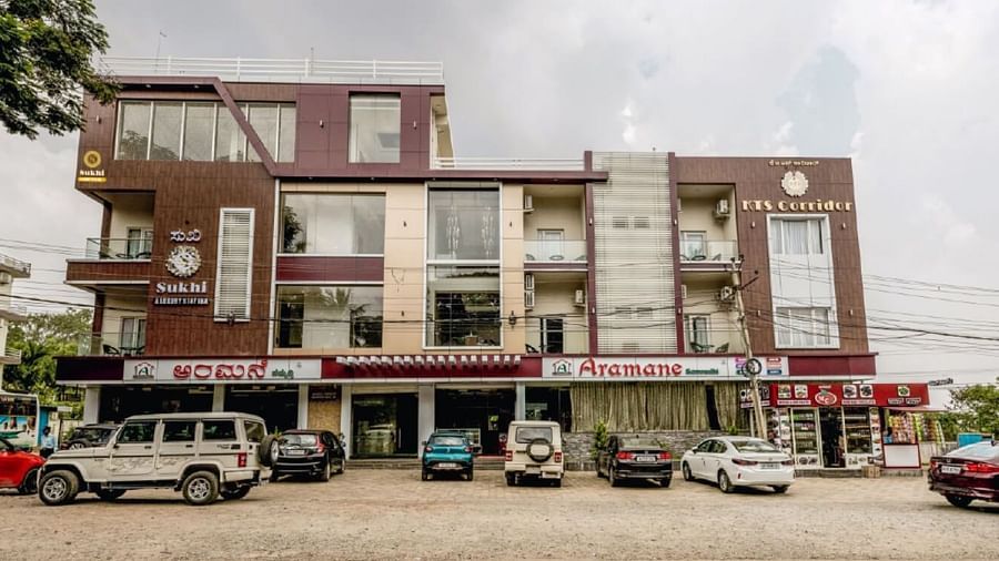 Facade image of Sukhi - A Luxury Stay Inn, Chikkamagaluru with several vehicles parked in the front.