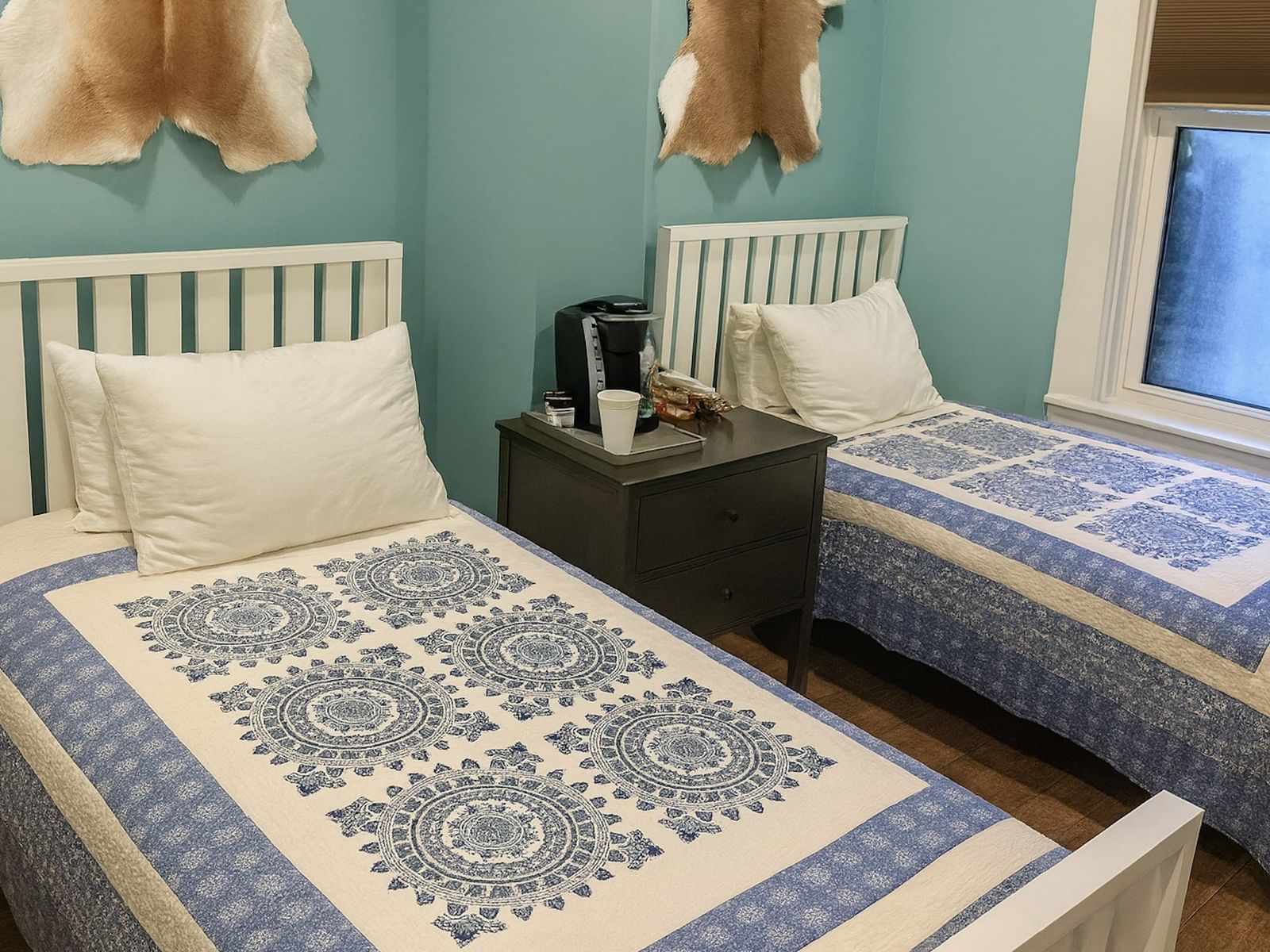 Deluxe Twin room at The Groverland Hotel, furnished with twin beds, a bedside table, and wooden flooring.