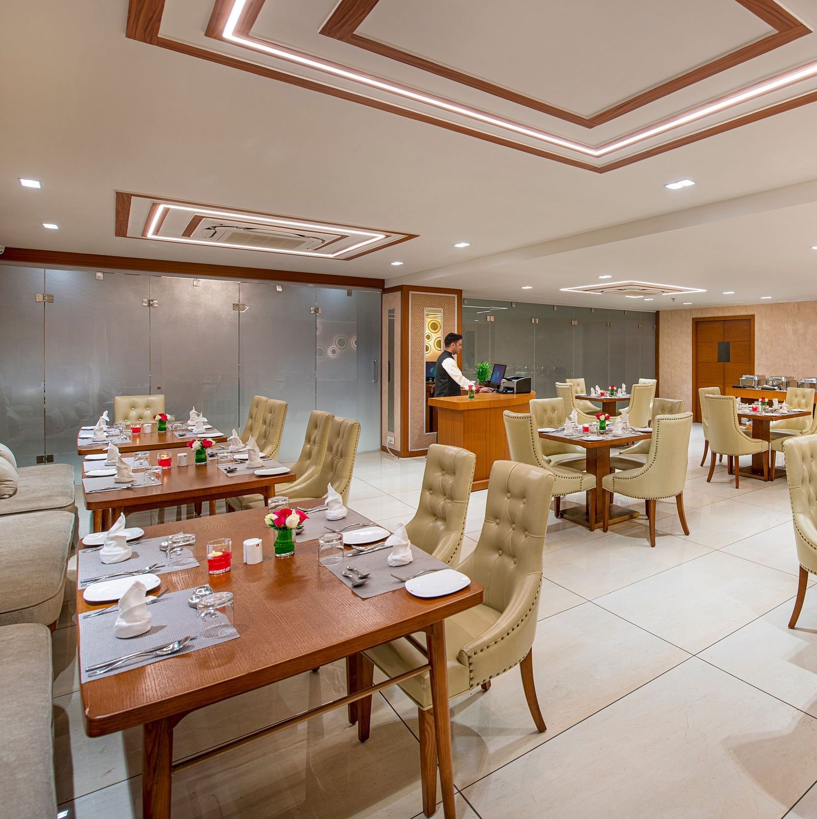 A hotel dining area with wooden tables and comfortable chairs, ready for guests to dine - SK Lords Inn Ahmedabad