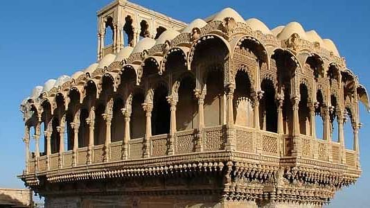 A facade image of a palace with a clear blue sky in the background
