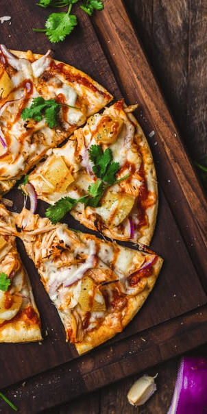 A pizza with various toppings on a wooden board.