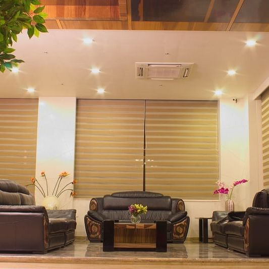 An inviting hotel entrance or lobby at Lords Inn Porbandar, with modern seating and natural light filtering through blinds.