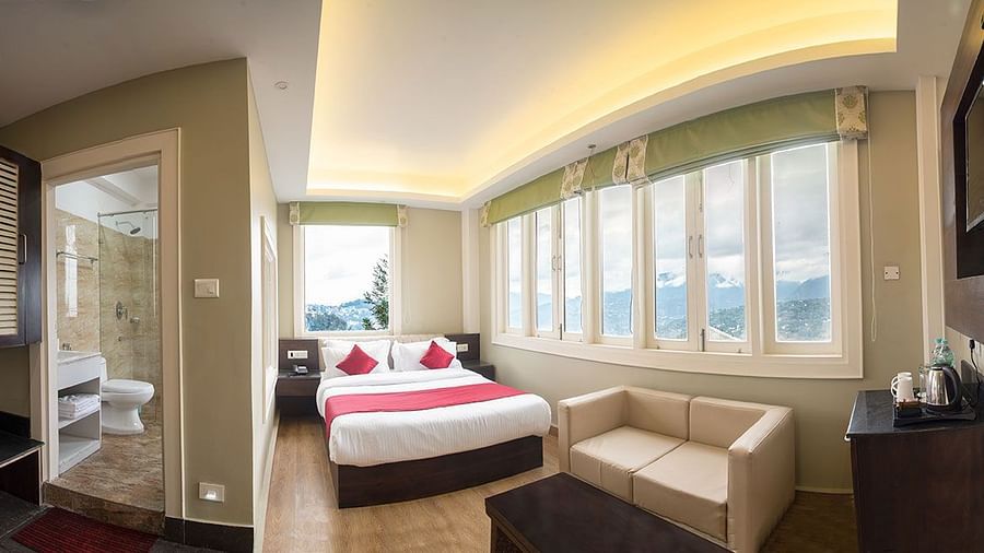 A panoramic view of a room featuring a bathroom and a bedroom with a bed and a seating area - Summit North Star, Gangtok