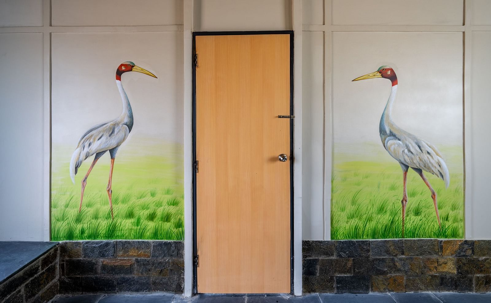 An image of door with two flamingos painted on either side of it
