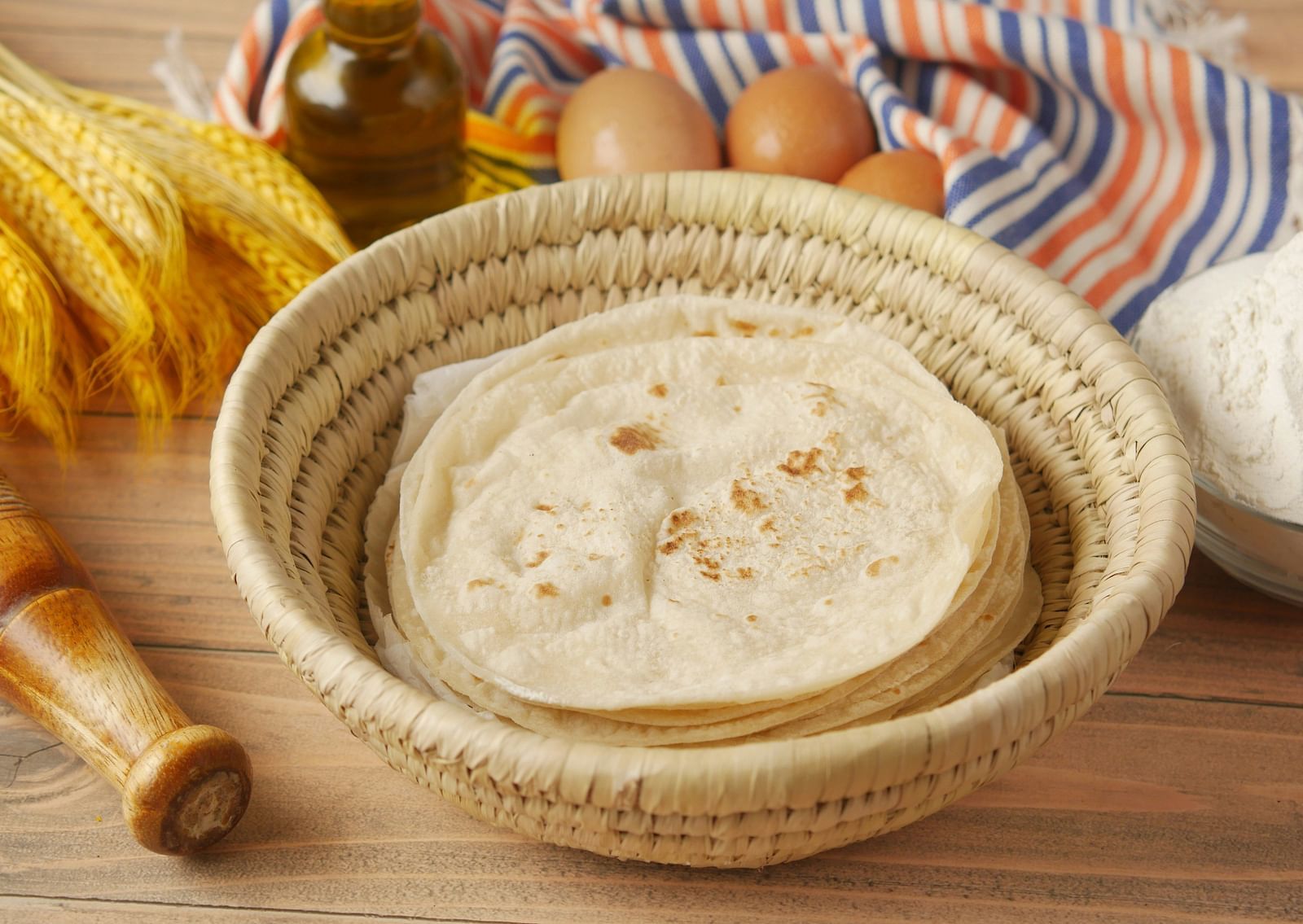 Many flour based dish kept inside a based with eggs next to it.
