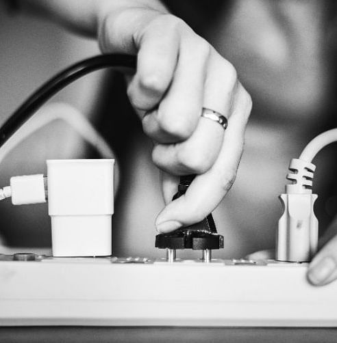 A plug point with a woman inserting a plug point