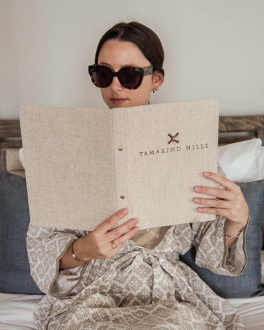 Guest reading a menu in a cosy villa room at Tamarind Hills Antigua – Resort & Villas, showcasing luxury and comfort