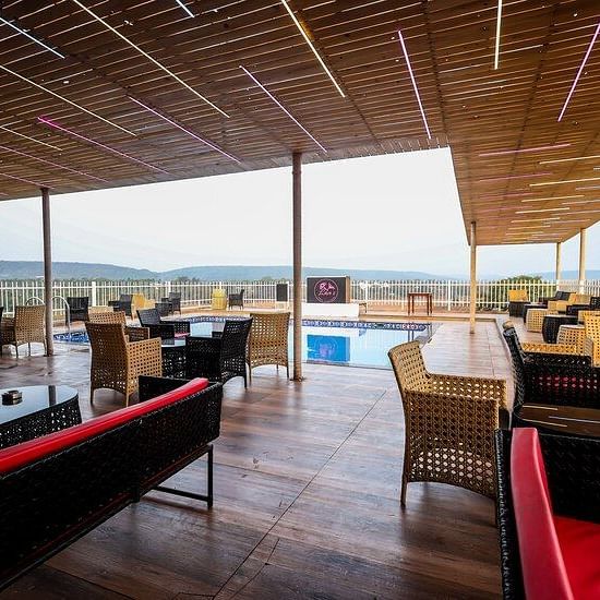 Seating area with chairs and sofas at the rooftop at Vagator Downtown, Goa