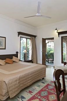 An image of a room with a bed, bed side table, chairs, tables, lamps, ceiling fan and other decorative items - MANVAR Resort & Desert Camp