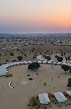 Twilight descends on the tented camp, captured from above, showing the landscape's vastness and the camp's seclusion - MANVAR Resort & Desert Camp