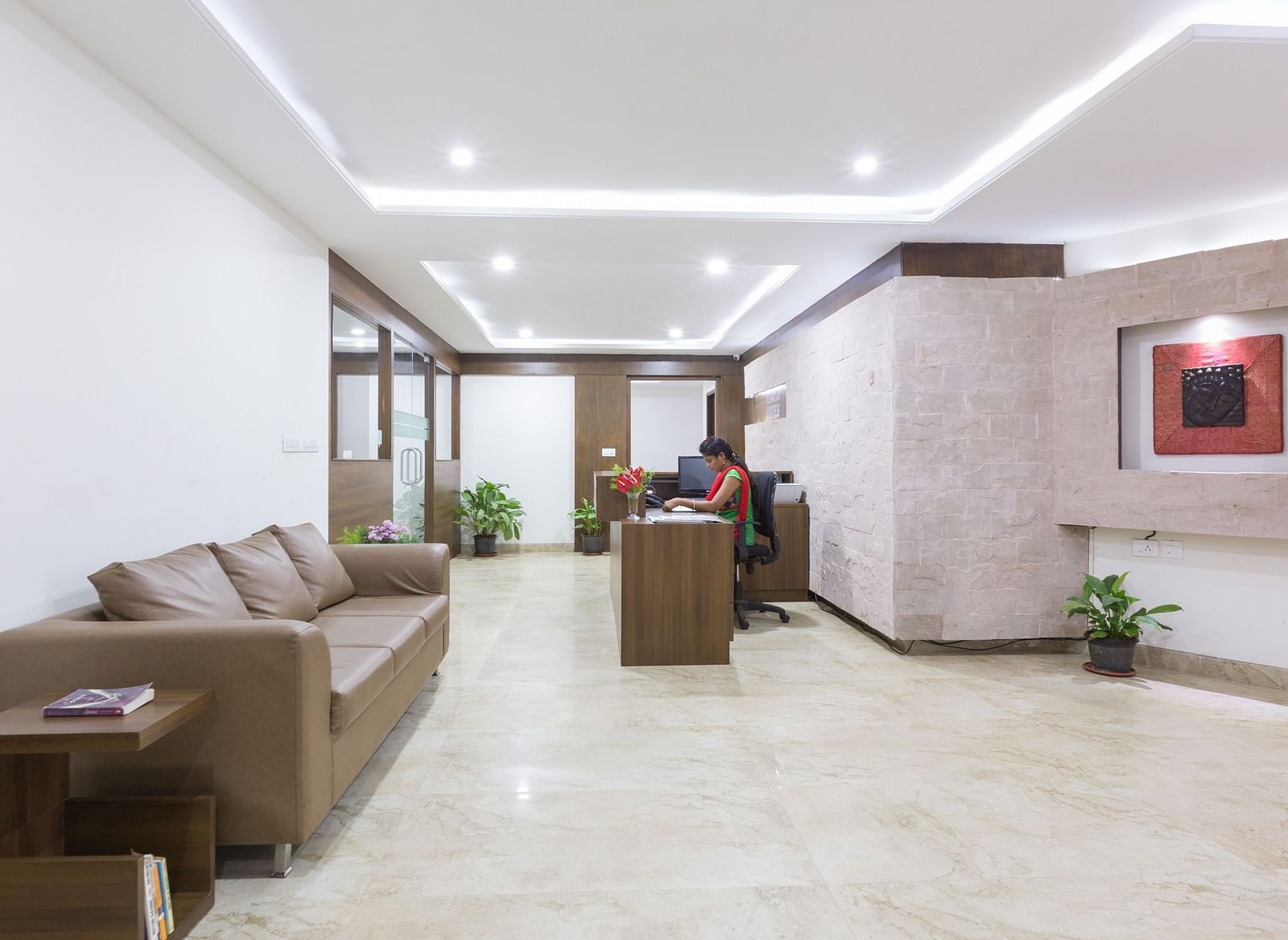 A lobby area with cushioned sofas, a coffee table, and decorative lighting on the ceiling - Sanctum Suites BEL Road, Bangalore
