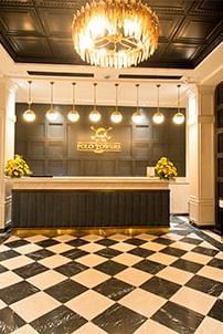  The reception and front desk area of the Polo Hotel Shillong, featuring a black and white tiled floor.