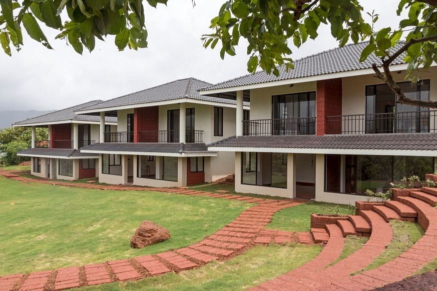 Exterior view of Forest Escapes Resort framed by tree leaves.