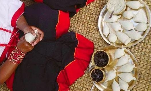 A women making Yoamri with rice flour, there are two plates placed before her