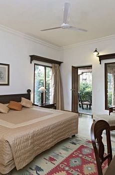 An image of a room with a bed, bed side table, chairs, tables, lamps, ceiling fan and other decorative items - MANVAR Resort & Desert Camp