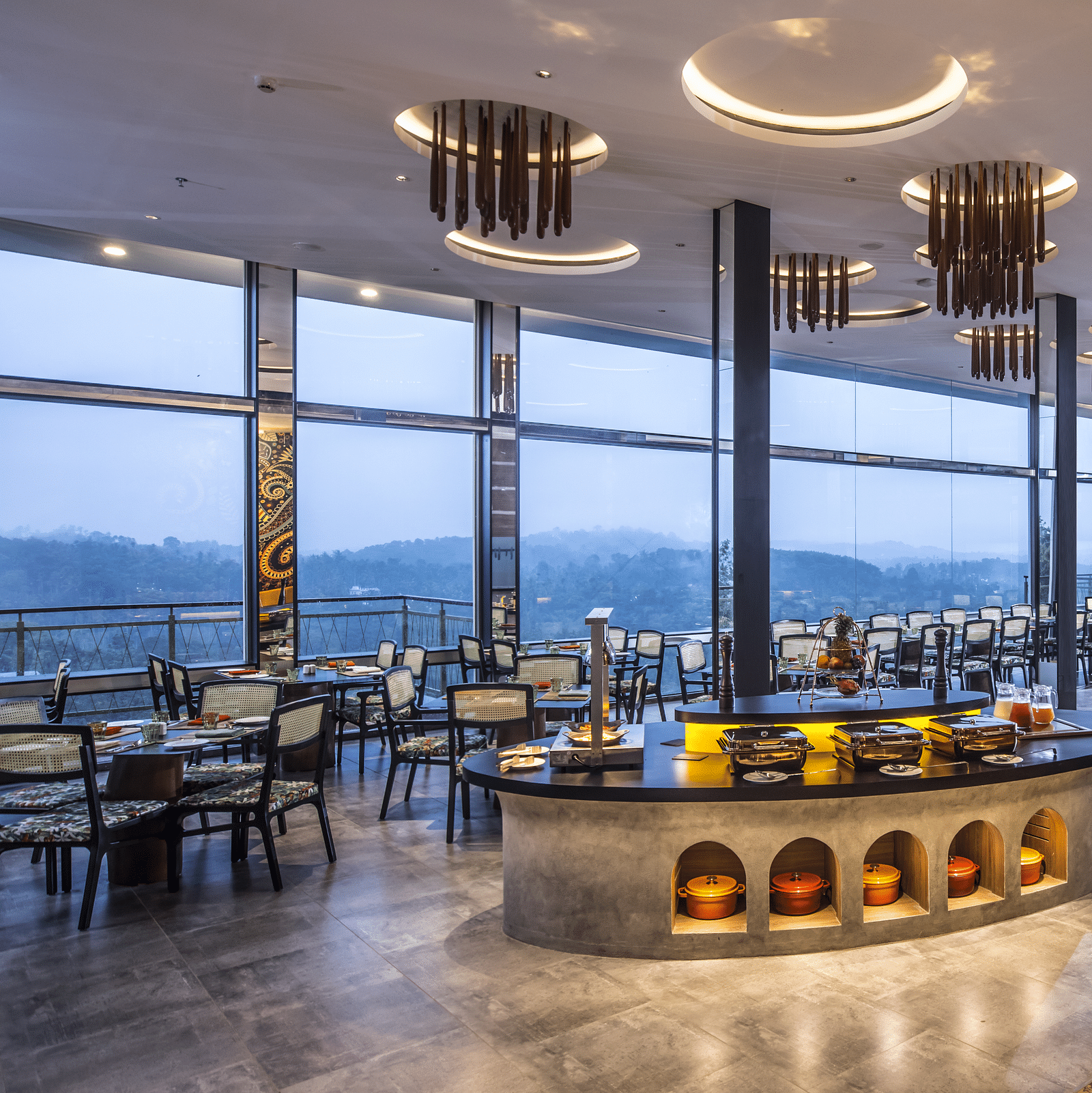 A modern restaurant with large windows offering panoramic views, elegant lighting, and a stylish interior design.