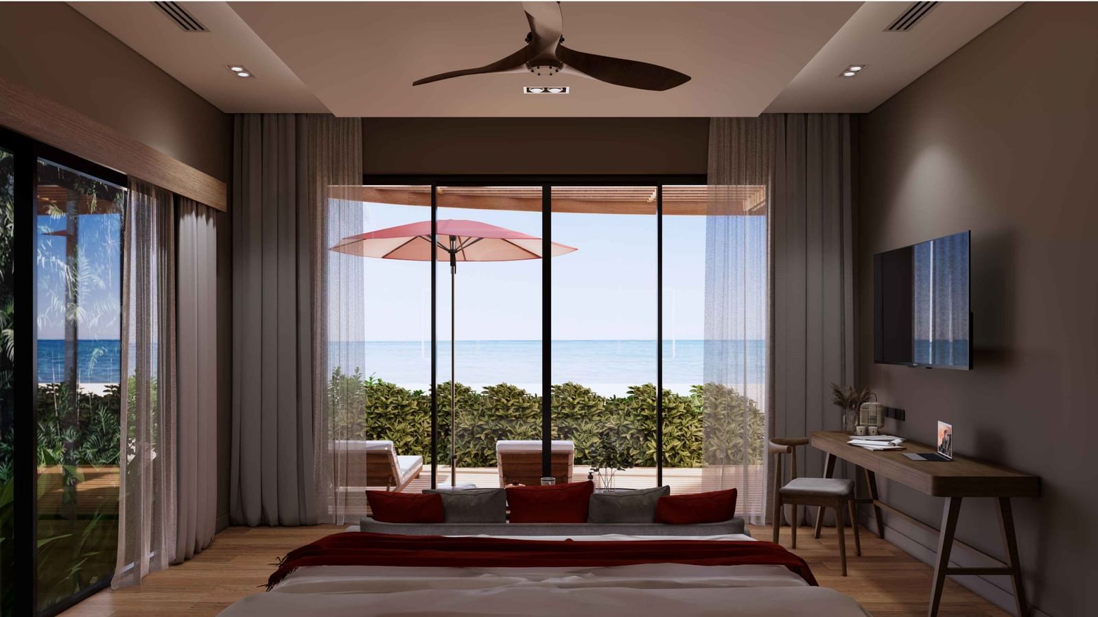 A bedroom with large glass doors opening to a private patio, red umbrella, sunbeds, and stunning ocean view at Ramada Resort by Wyndham Khao Lak.