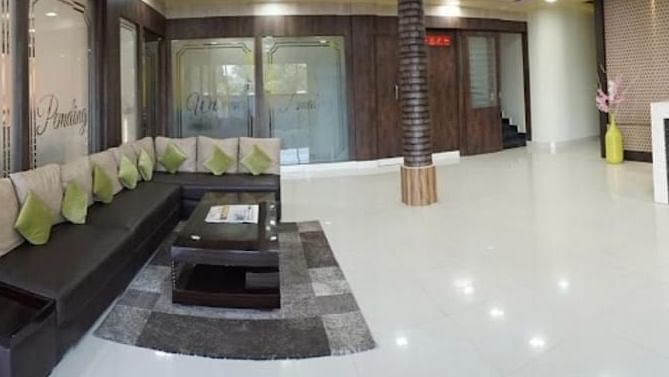 A stylish double room with purple decor, warm lighting, and comfortable seating arrangements -  Pemaling Lords Eco Inn Guwahati