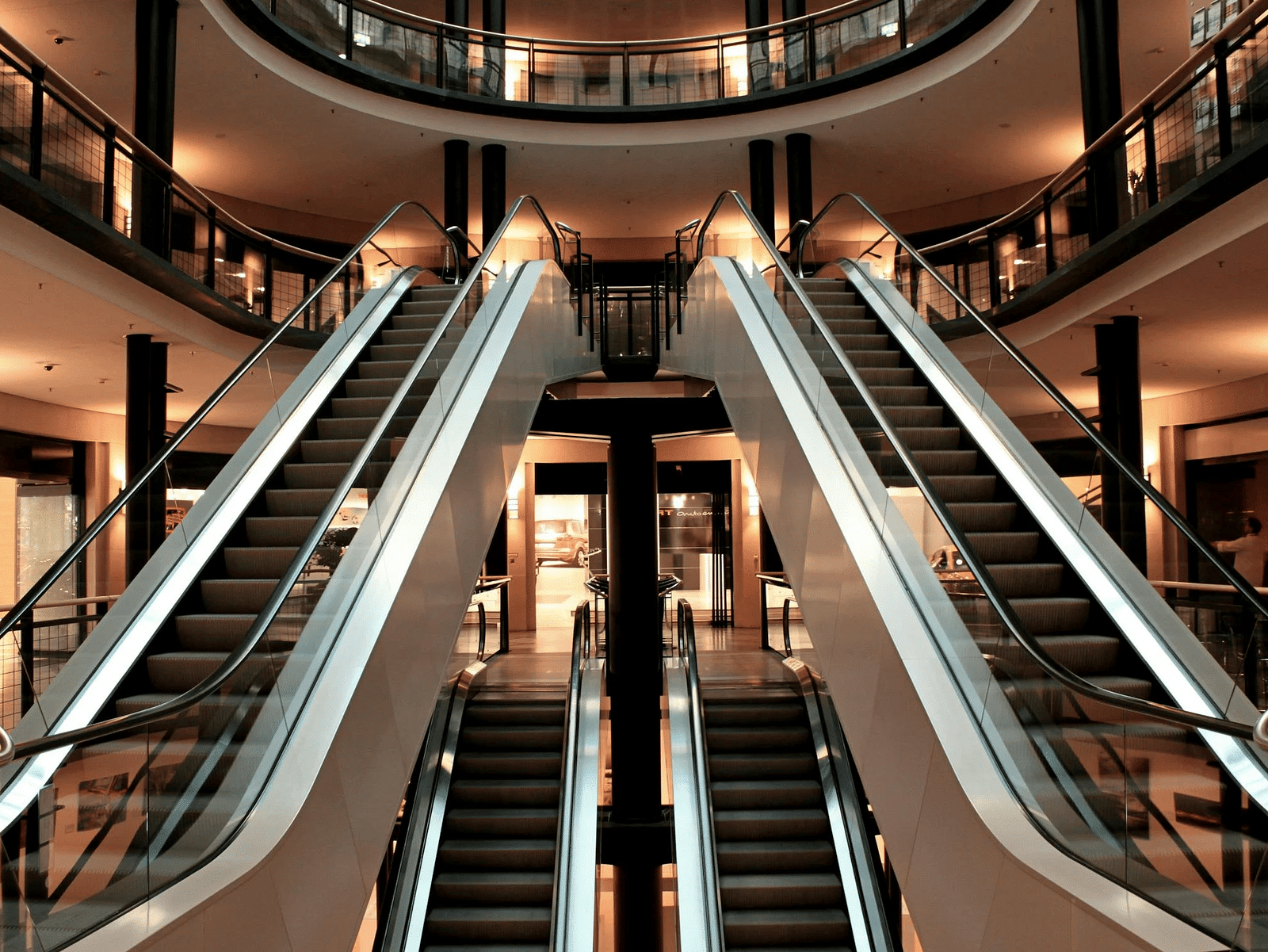 Image of two escalators going up and down in a mall.