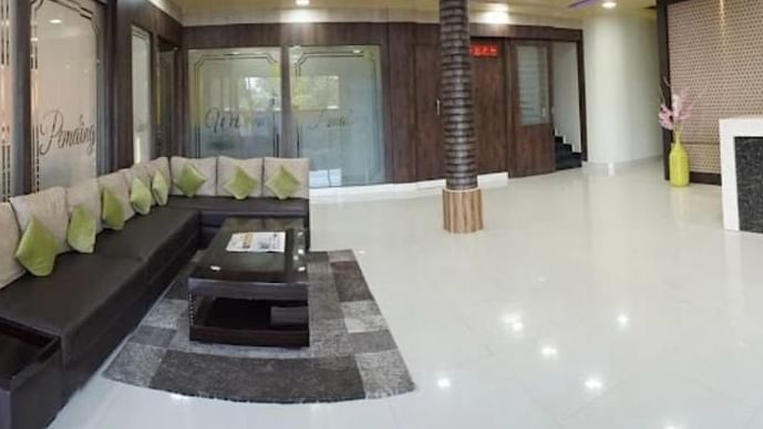 A stylish double room with purple decor, warm lighting, and comfortable seating arrangements -  Pemaling Lords Eco Inn Guwahati