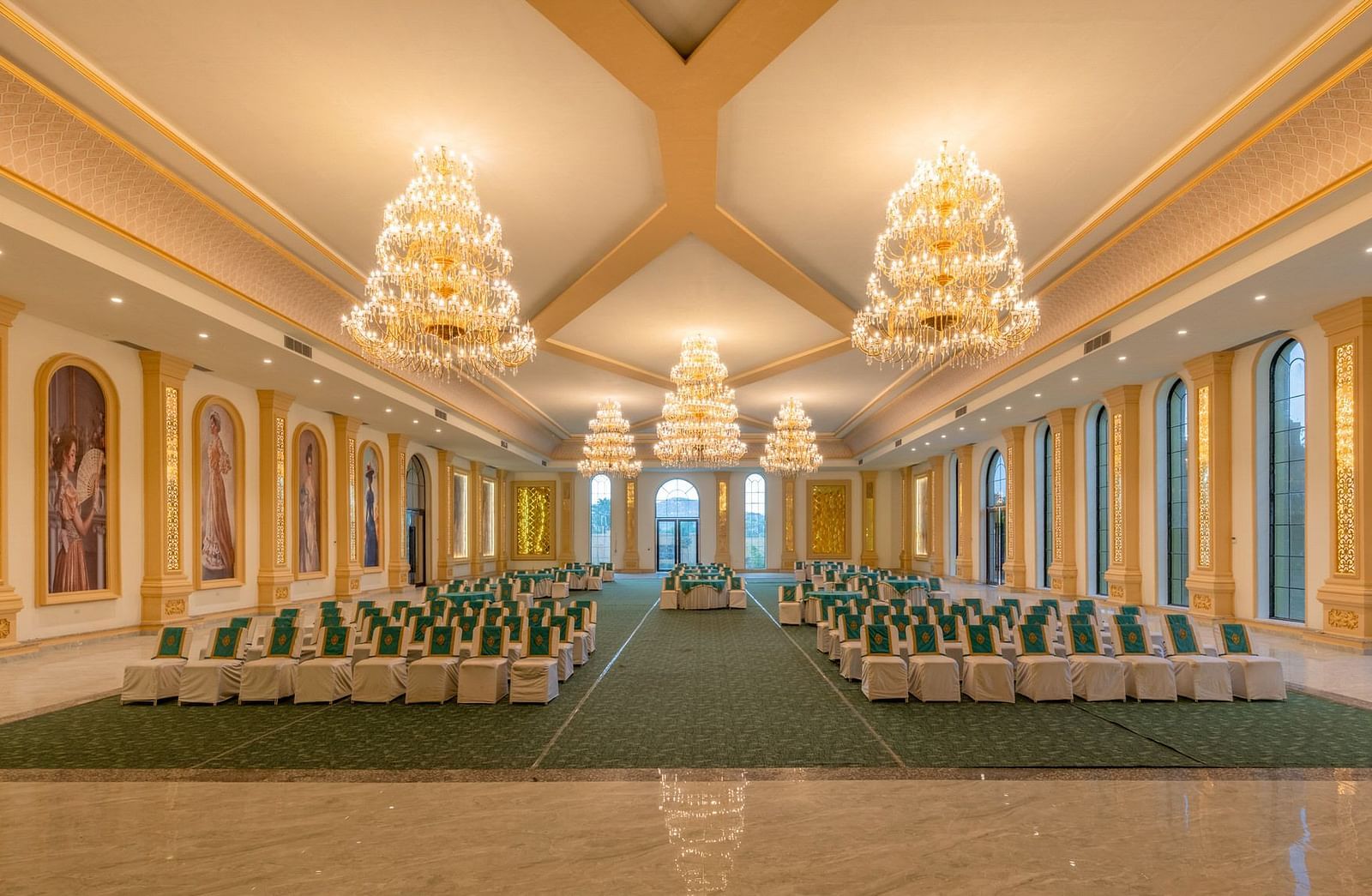 Front view of a banquet hall with neatly arranged chairs and chandeliers adorning the ceiling at Valley by Grassfield.