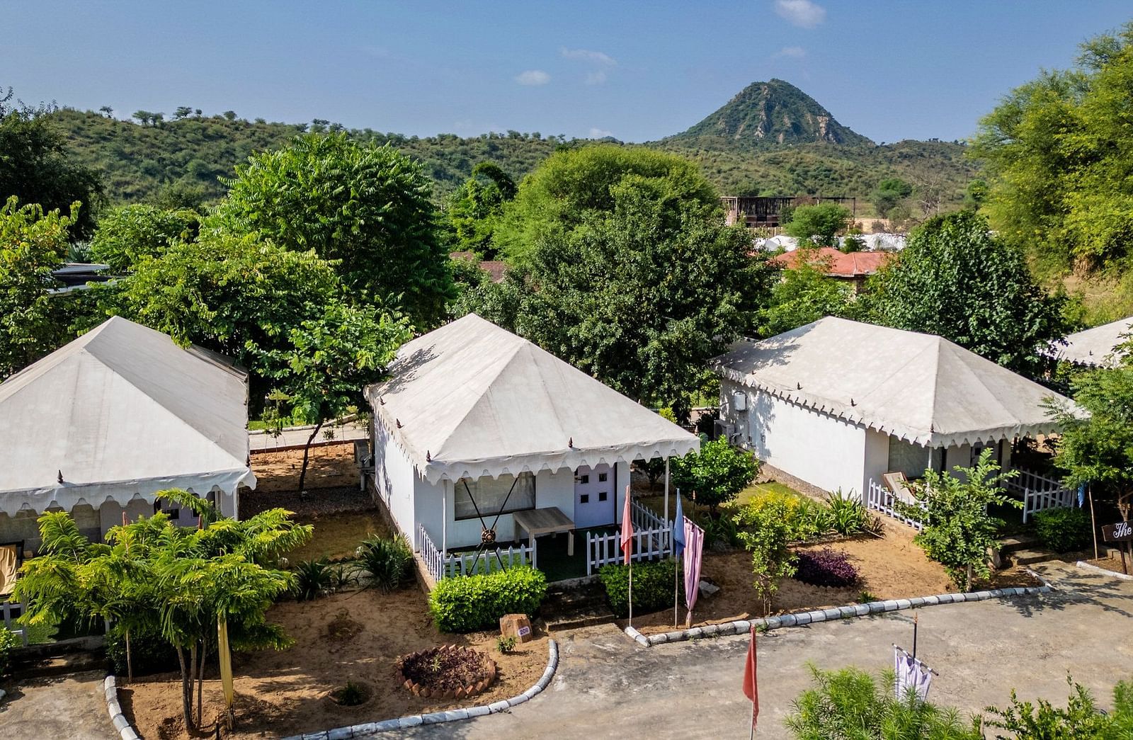 Aerial view of tent-style accommodations at Valley by Grassfield, nestled amidst lush trees and greenery.