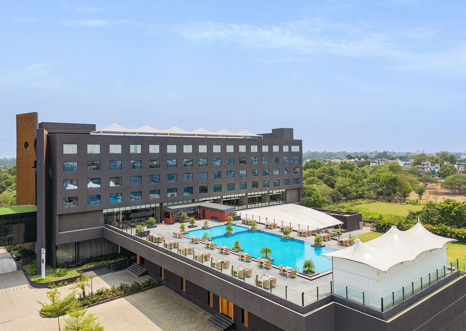 Exterior with the swimming pool in view of Essentia Luxury Hotel, Indore, during the day.