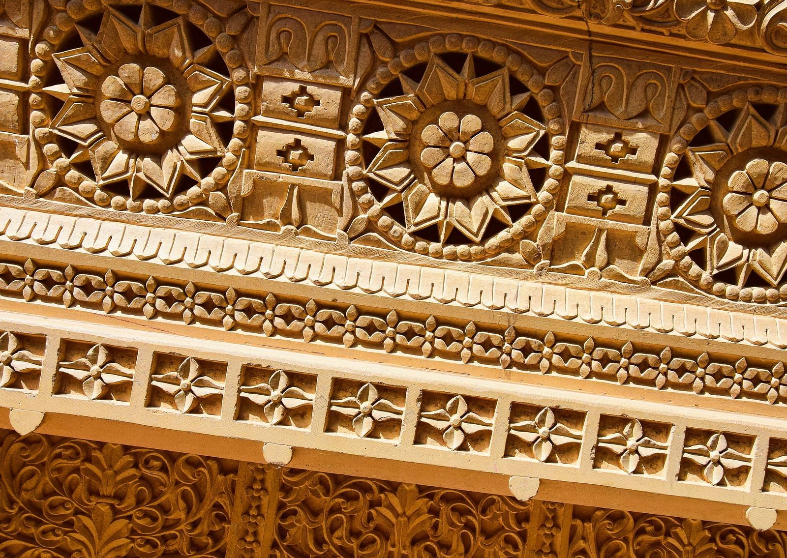 A close up shot of an intricate wooden carving  with different designs.