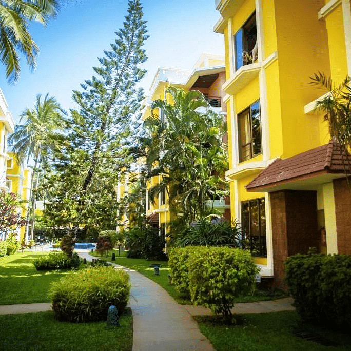 The exterior yellow facade of Adamo The Bellus, hotel in Goa